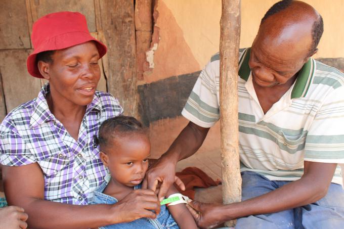 Ndakaitei and husband measure their daughter, Miltread's MUAC