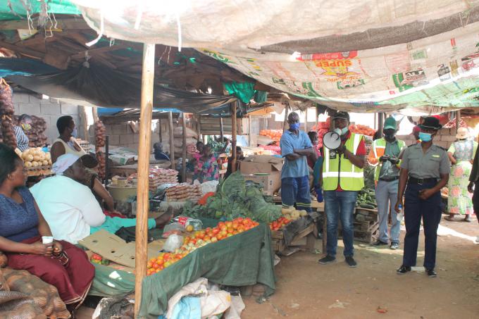 Making use of a loudhailer to distribute COVID-19 messages in at a busy market Beitbridge district