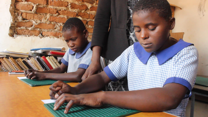 Ennert and her fellow classmates writing an assignment in braille at the Mahuwe School Resource Centre for the Visually impaired, which was established with support from Save the Children.
